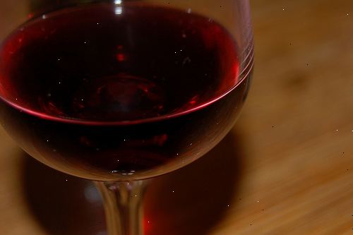 Hur tar man bort ett rött vin fläck från ett trägolv eller bord. Torka upp det röda vinet spill om det inte helt har torkat, med en våt pappershandduk eller våt absorberande trasa.