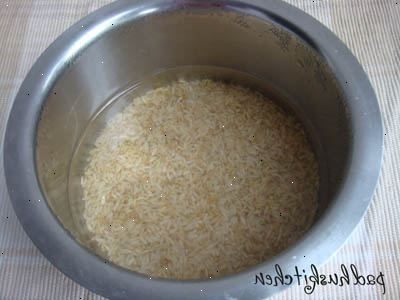 Hur man lagar ris i en riskokare. Mät ris med en kopp och lägg den i din matlagning potten.