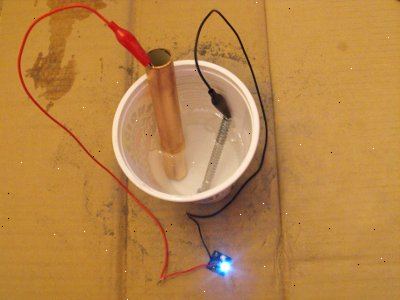 Hur man gör en hemmagjord batteri. Häll innehållet i en läsk kan in i en plastbägare.