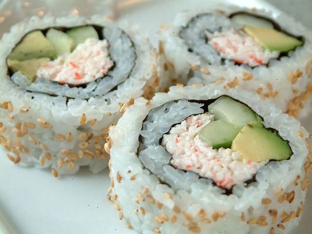 Hur man gör en California Roll. Använd saran wrap för att täcka din matta sushi rullande.