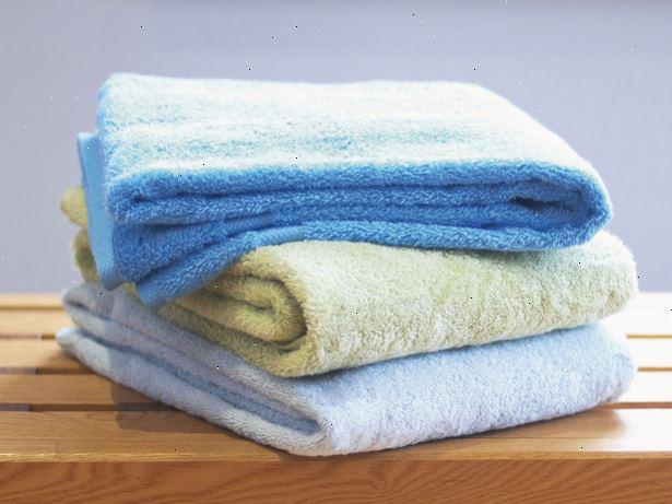 Hur att vika badlakan. Håll varje handduk av hörnen på samma sida av den kortare kanten.