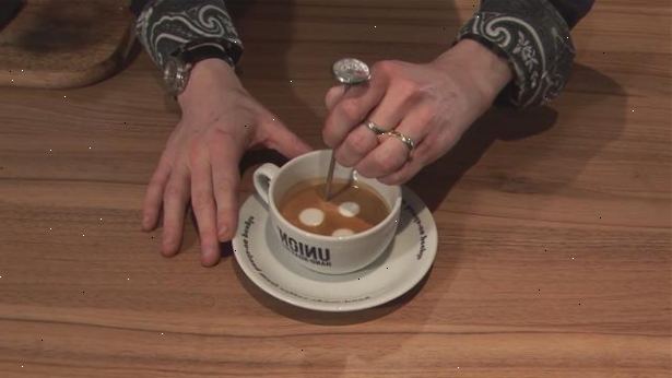 Hur man gör en macchiato kaffe. Sätt spetsen på munstycket vid ytan av mjölken.
